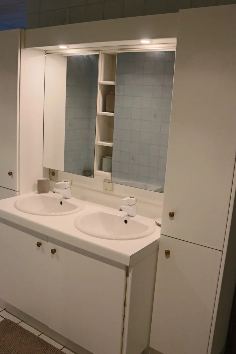 Badkamer met douchecabine en bad, wasmachine en droogkast